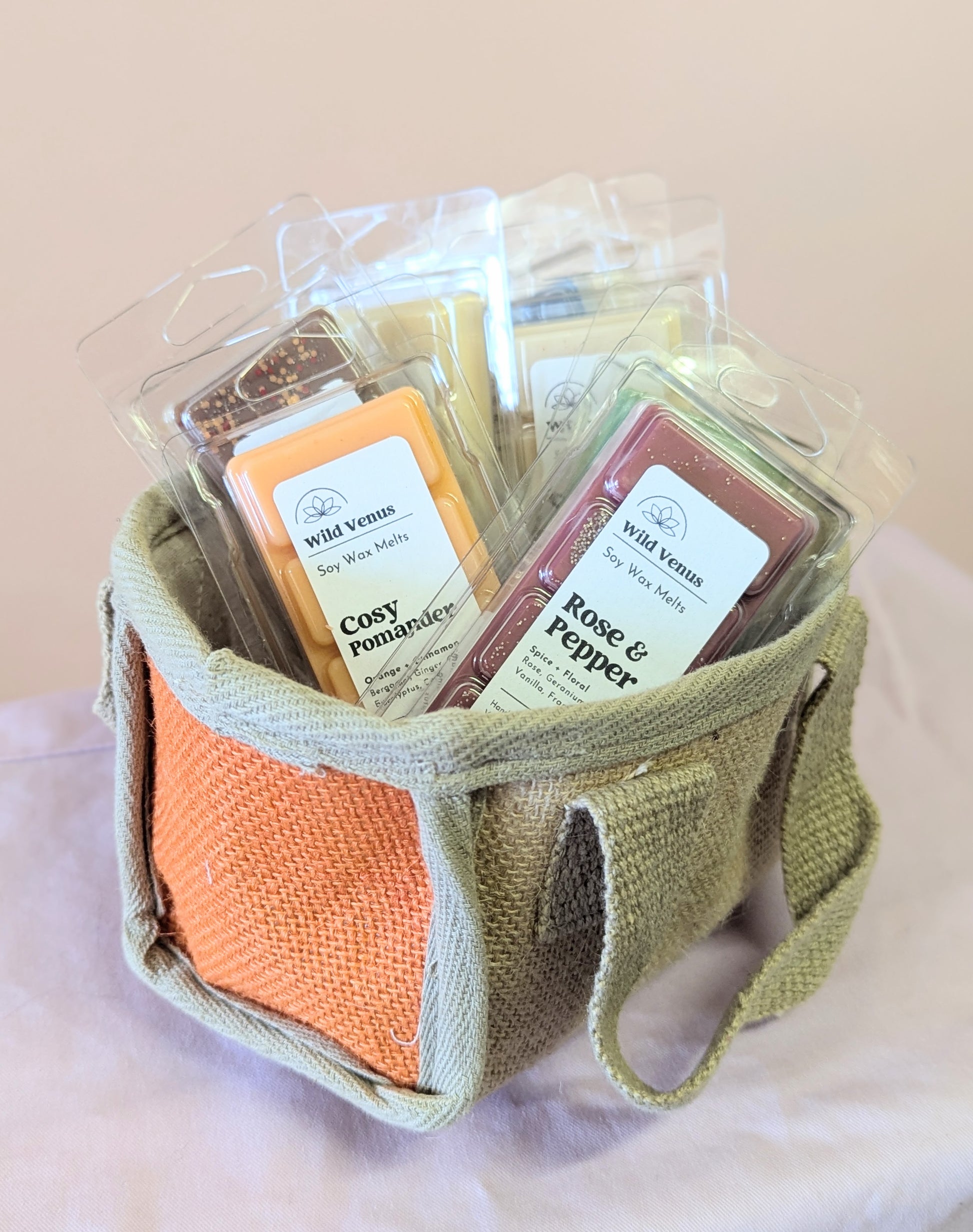 An orange jute basket with handles styled with wax melts in for the Super Seconds Festival.