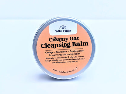 A tin of Creamy Oat Cleansing Balm on its side which shows the top of the tin with the label showing. The product is against a plain white background. 