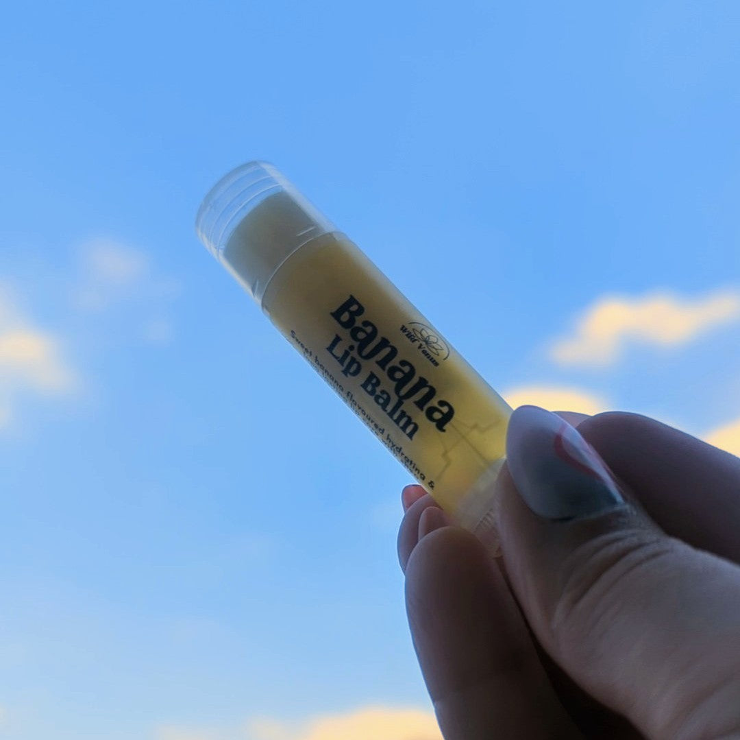 Holding a banana lip balm up to the sky.