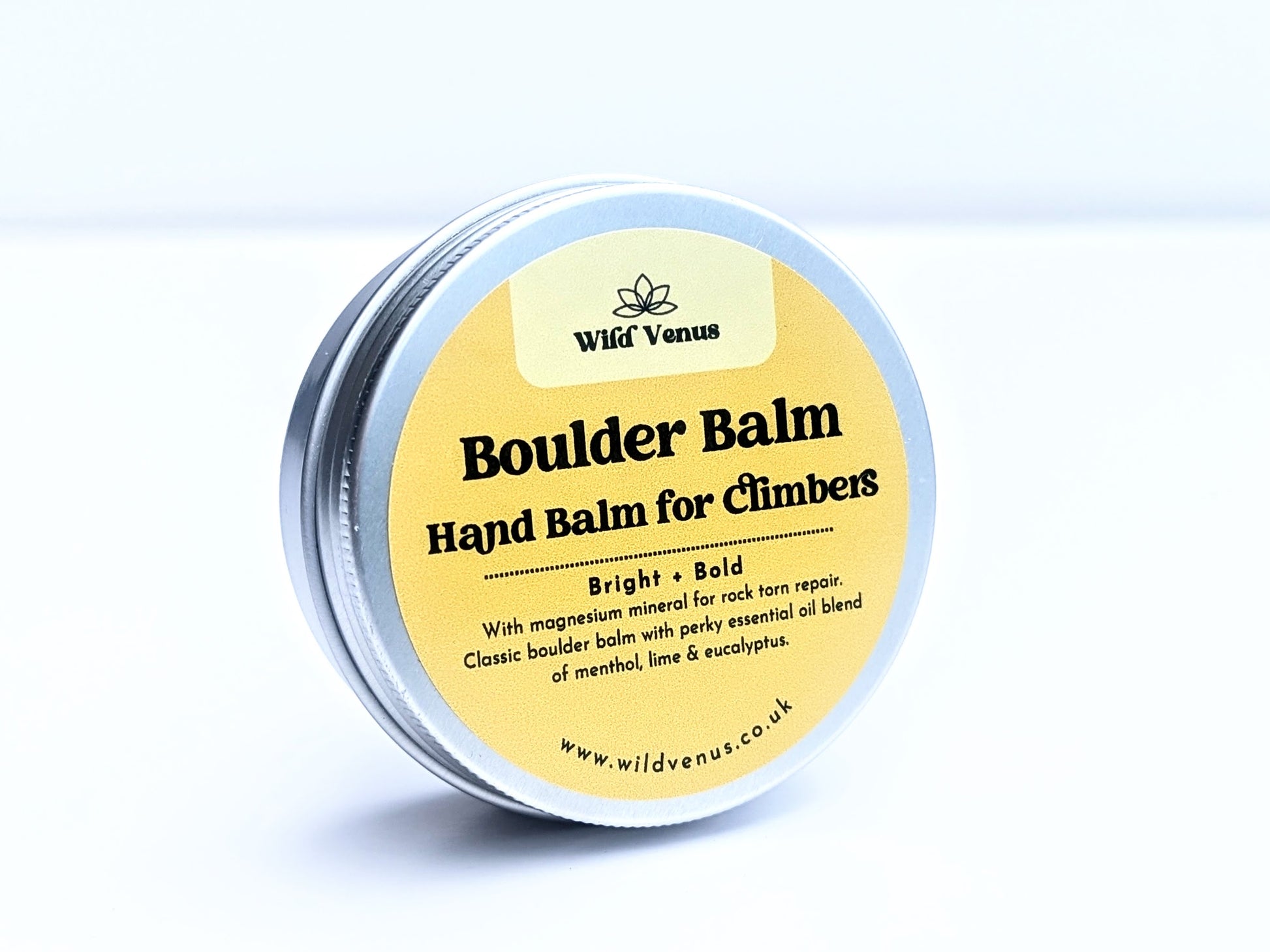 A tin of Boulder Balm Hand Balm for Climbers. The product is on its side and slightly angled away from the camera, with the top of the tin showing the label. The product is against a white label. 