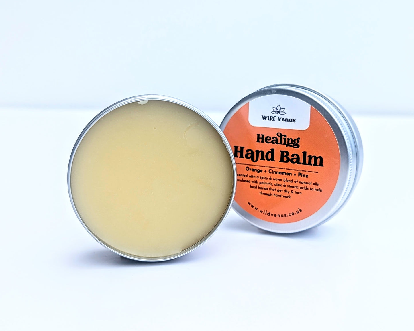 An open container of the Healing Hand Balm. The balm is shown against a white background and the tin lid is tucked behind.