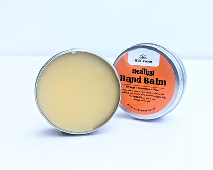 An open container of the Healing Hand Balm. The balm is shown against a white background and the tin lid is tucked behind.
