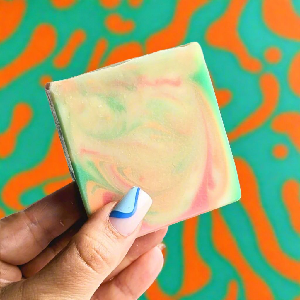 Holding a soul sister soap in front of a groovy orange and green background. 