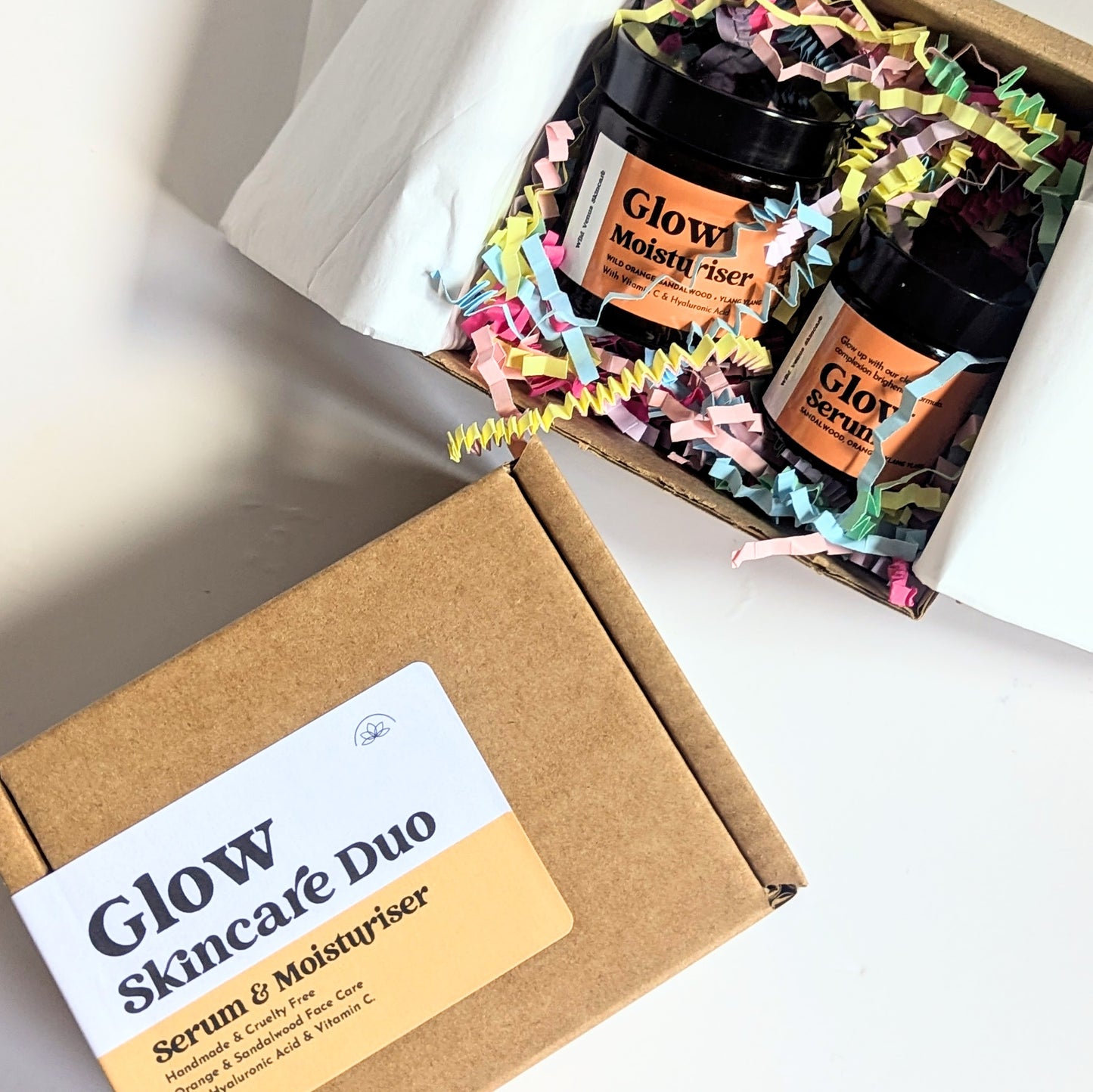 There are two boxes of Glow Skincare Duo Gift Boxes. They are both shown against a white surface. The birdseye view shows one box is closed and the other lid is open which shows the colourful packaging and products inside. 