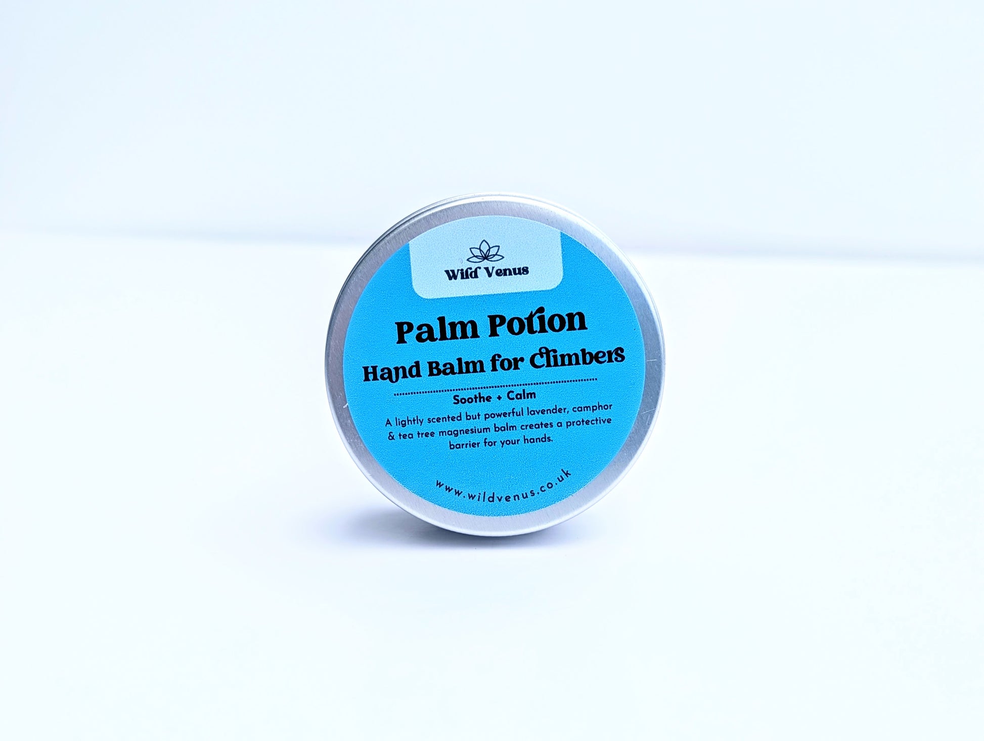 A tin of Palm Potion Hand Balm for CLimbers. The tin is on its side with the label facing the viewer against a plain white background. 