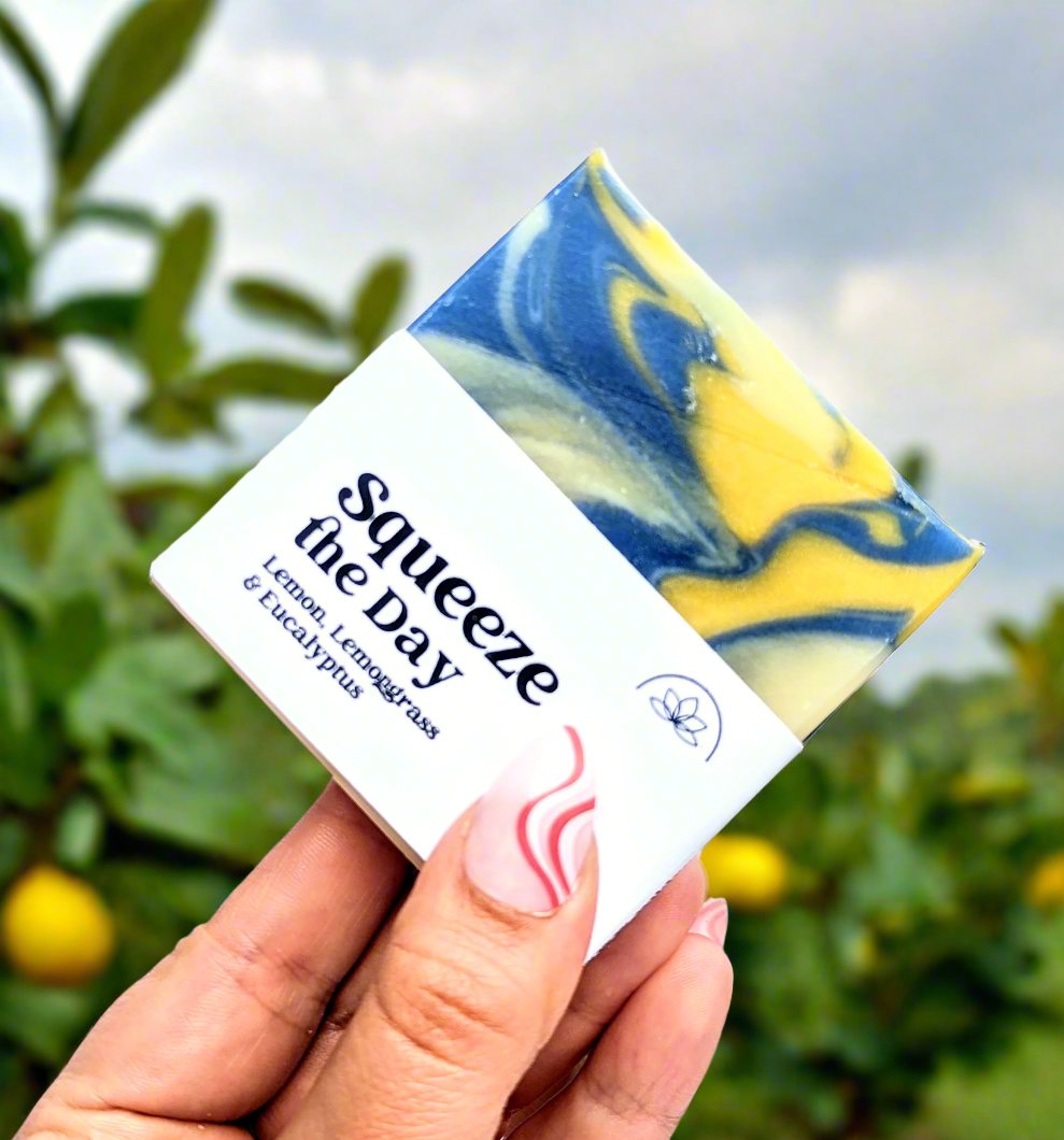 Holding a bar of Squeeze the day soap in a lemon grove.