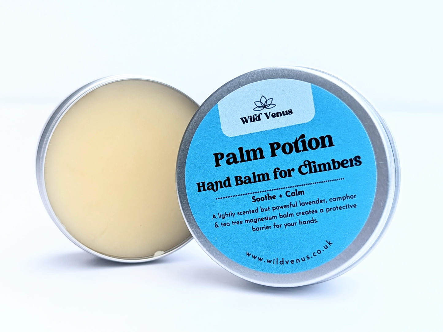 An open tin of Palm Potion Hand Balm for Climbers. The tin is on its side with the label facing the viewer against a plain white background. 