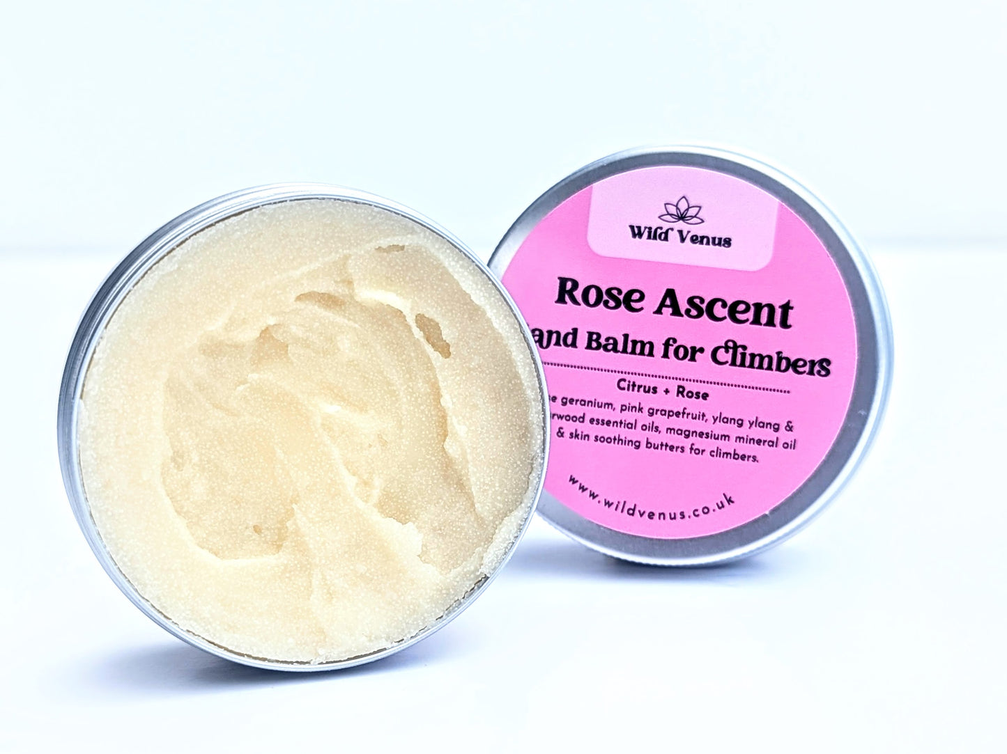 An open tin of Rose Ascent Hand Balm for Climbers. The tin is on its side with the balm facing the viewer against a plain white background. The tin lid is slightly tucked behind the tin and the label is facing the viewer. 