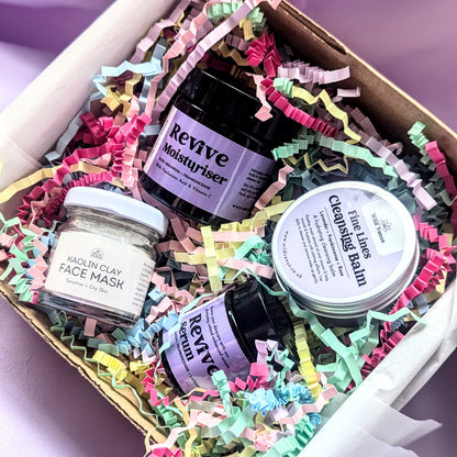  A close up of the She's so Fine Face Care Gift Box is open showing all the products inside. The gift box is shown on a pale lilac background.