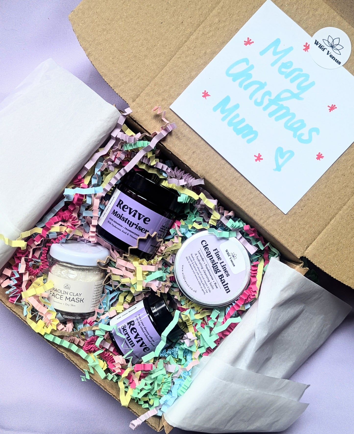 The She's so Fine Face Care Gift Box is open showing all the products inside. On the inside of the lid, there is a handwritten note which reads " Merry Christmas Mum" there are stars and hearts also drawn on the note.