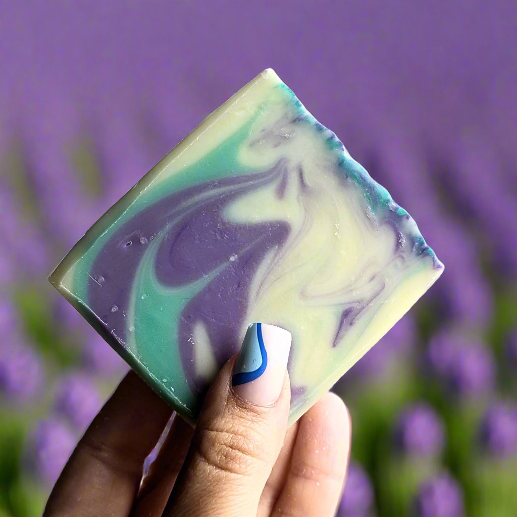 Holding a naked lavender and tea tree soap up against a field of lavender.