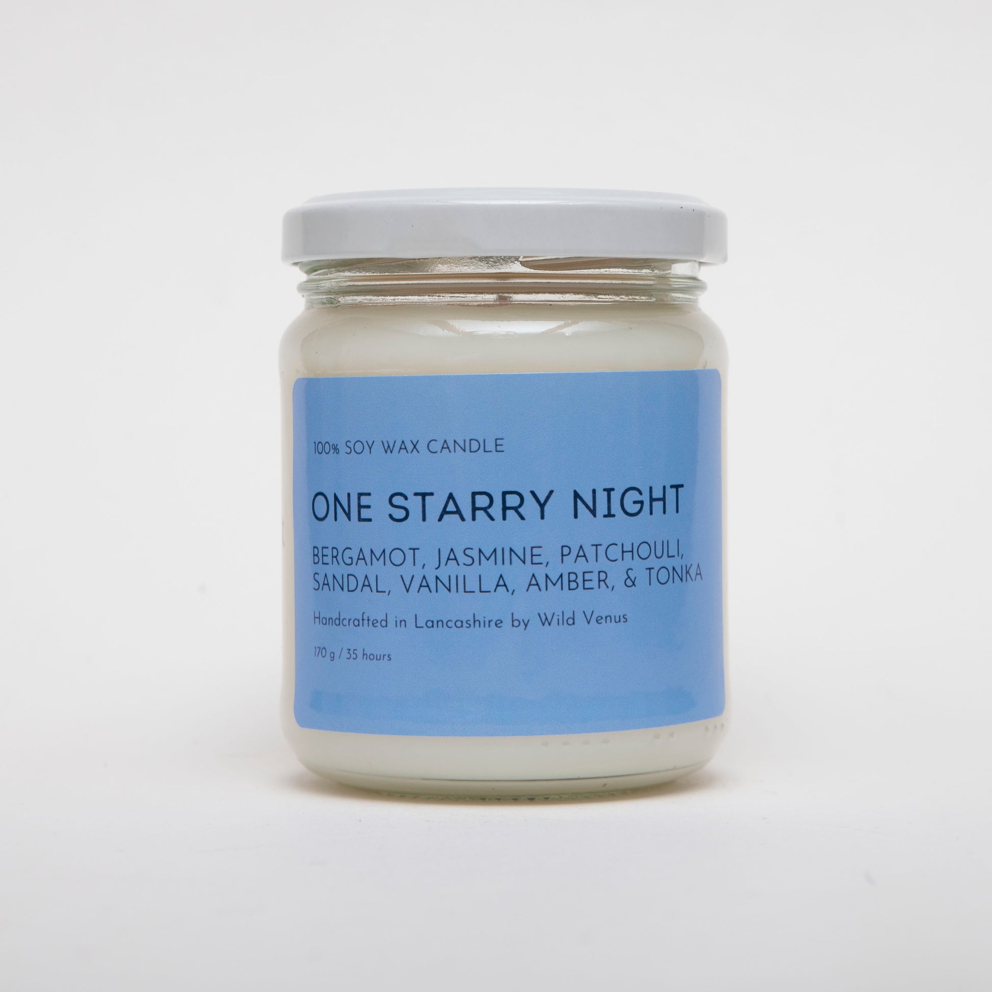 The One Starry Night Candle is a simple white candle with a bold label. The candle has scent notes of bergamot, jasmine, patchouli, sandal, vanilla, amber and tonka. 